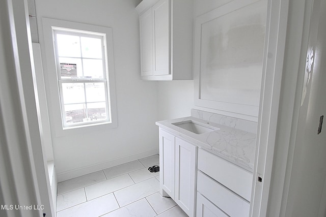 laundry room featuring a sink and baseboards