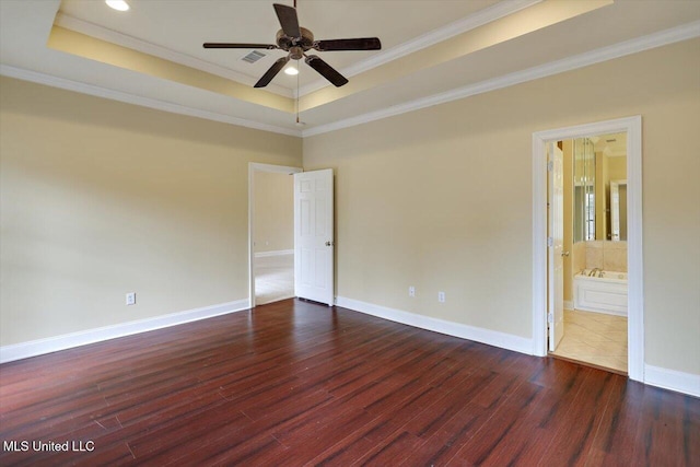 spare room featuring crown molding, a tray ceiling, dark hardwood / wood-style floors, and ceiling fan