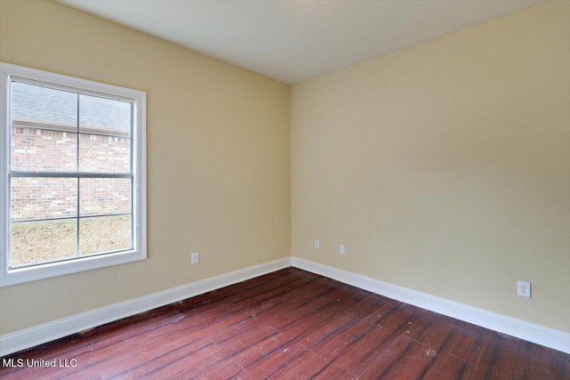 empty room featuring dark hardwood / wood-style flooring and a healthy amount of sunlight