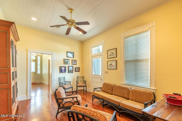 living area featuring recessed lighting, a ceiling fan, baseboards, and wood finished floors