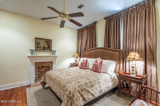 bedroom featuring visible vents, baseboards, ceiling fan, and wood finished floors