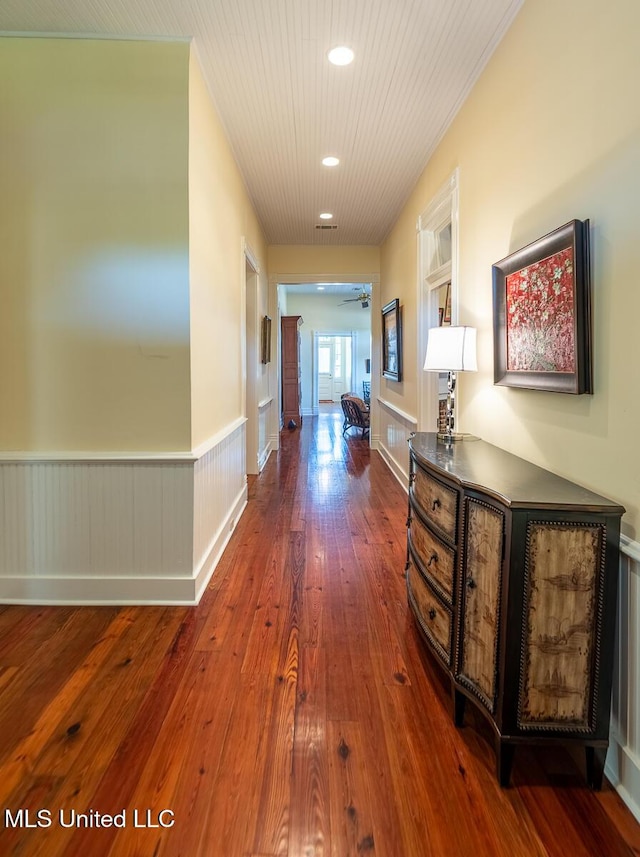 corridor with wainscoting, recessed lighting, and dark wood-type flooring
