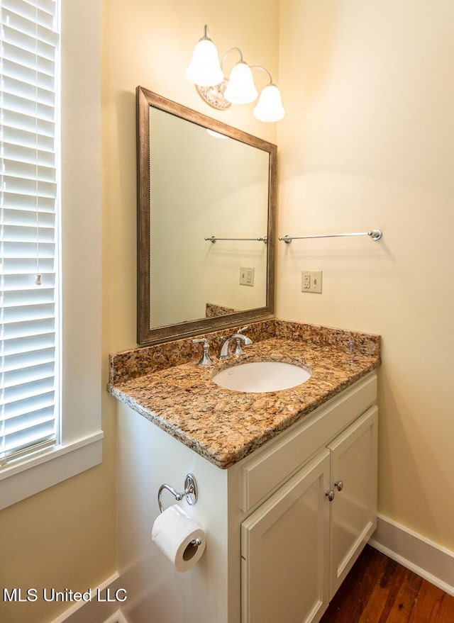 bathroom featuring baseboards, vanity, and wood finished floors