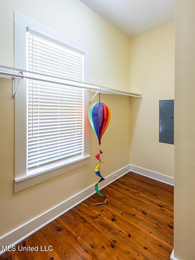 interior space with wood-type flooring, baseboards, and electric panel