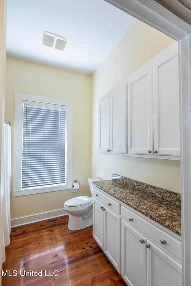 bathroom featuring visible vents, wood finished floors, toilet, and vanity
