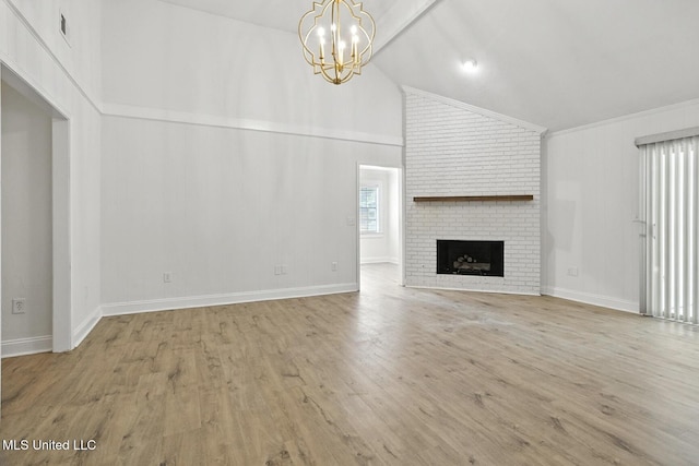 132 Bent Creek Dr, Brandon, MS 39047 - unfurnished living room featuring a chandelier, a brick fireplace, wood finished floors, high vaulted ceiling, and crown molding