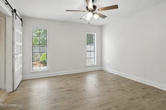 132 Bent Creek Dr, Brandon, MS 39047 - unfurnished room with a barn door, healthy amount of natural light, light wood-type flooring, and a ceiling fan
