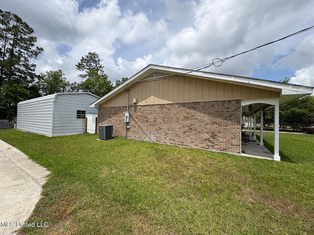 710 Beyer Dr, Bay Saint Louis, MS 39520 - view of property exterior featuring a lawn, brick siding, central AC, and a patio