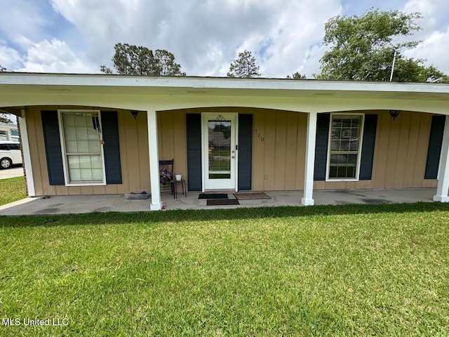 710 Beyer Dr, Bay Saint Louis, MS 39520 - property entrance featuring a lawn, board and batten siding, and a porch