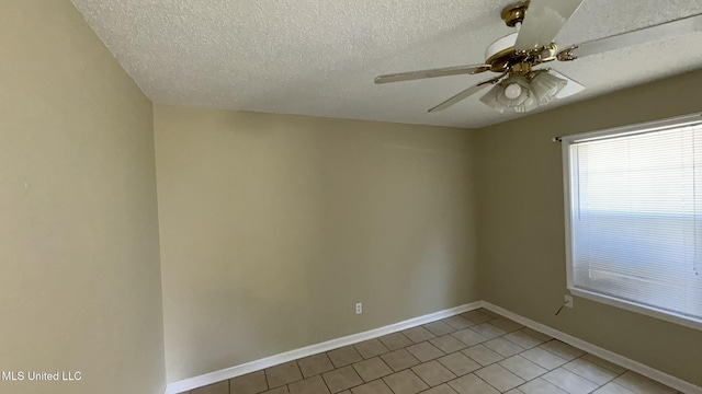 tiled empty room with ceiling fan and a textured ceiling