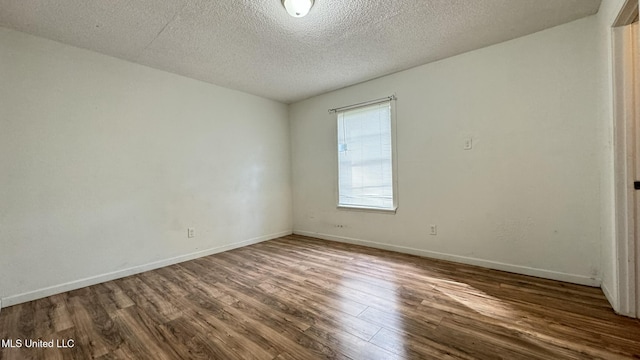 unfurnished room featuring dark hardwood / wood-style floors and a textured ceiling