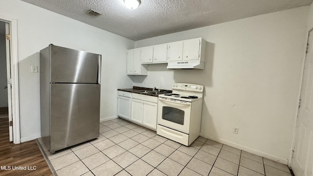 kitchen with sink, white electric range, white cabinets, and stainless steel refrigerator