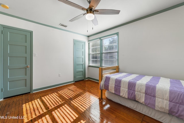 bedroom featuring hardwood / wood-style floors, ceiling fan, and ornamental molding