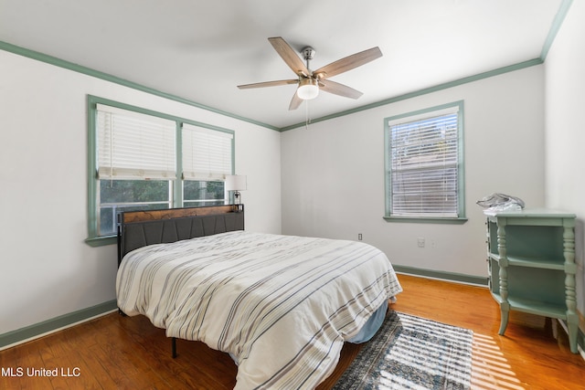 bedroom featuring hardwood / wood-style floors, ceiling fan, and ornamental molding