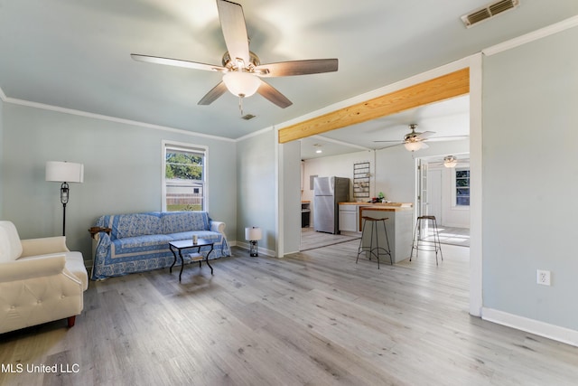 living room with ceiling fan, light wood-type flooring, and crown molding