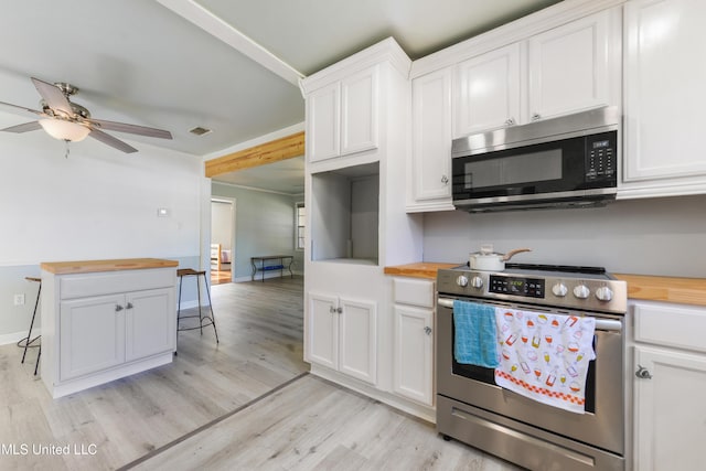 kitchen featuring wood counters, stainless steel appliances, ceiling fan, white cabinets, and light hardwood / wood-style floors