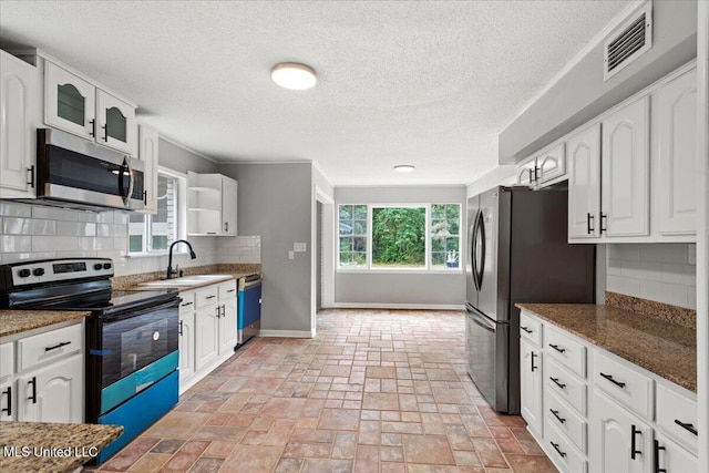 kitchen featuring tasteful backsplash, white cabinets, and appliances with stainless steel finishes