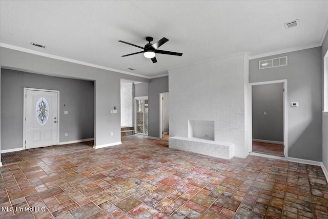 unfurnished living room featuring ceiling fan, crown molding, and a brick fireplace