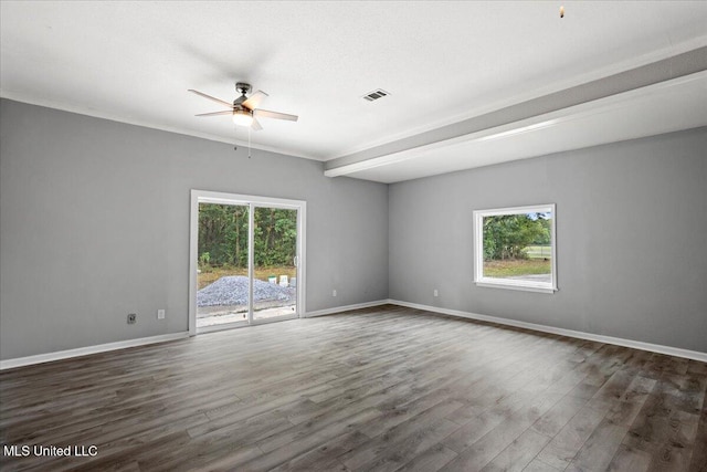 spare room with ceiling fan, a healthy amount of sunlight, dark hardwood / wood-style flooring, and beam ceiling