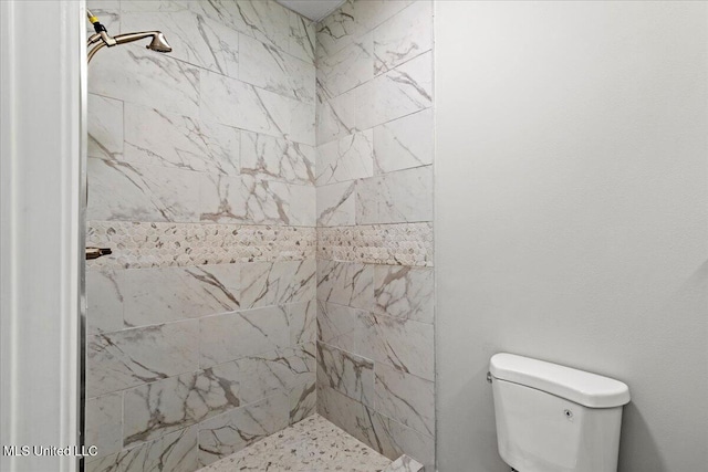 bathroom with toilet and a tile shower