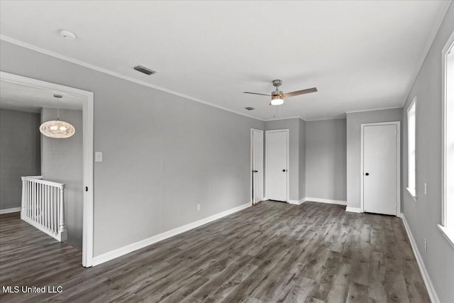 spare room featuring crown molding, ceiling fan with notable chandelier, and dark hardwood / wood-style floors