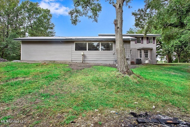 rear view of house featuring a yard and central AC unit