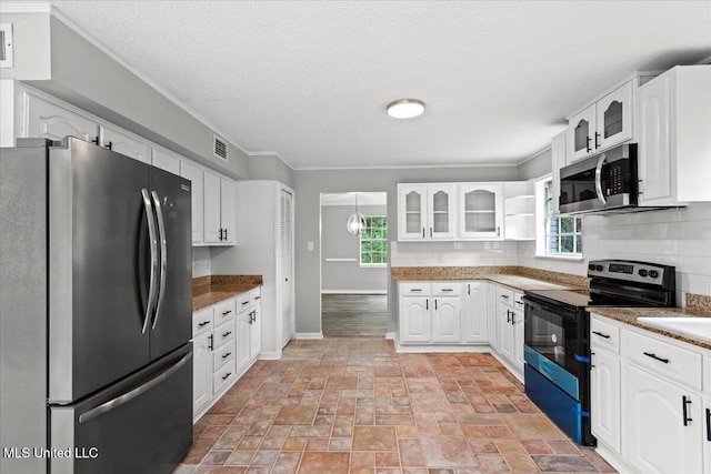 kitchen with white cabinetry, dark stone countertops, a wealth of natural light, and stainless steel appliances