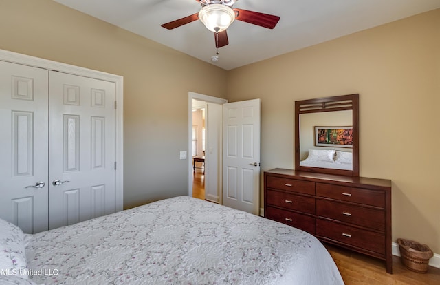 bedroom featuring light wood-style floors, baseboards, a ceiling fan, and a closet