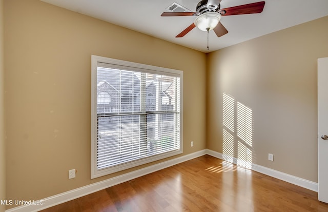 unfurnished room with light wood-style floors, visible vents, plenty of natural light, and baseboards