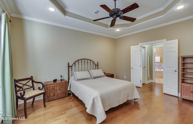 bedroom featuring visible vents, a raised ceiling, ornamental molding, light wood-style floors, and recessed lighting