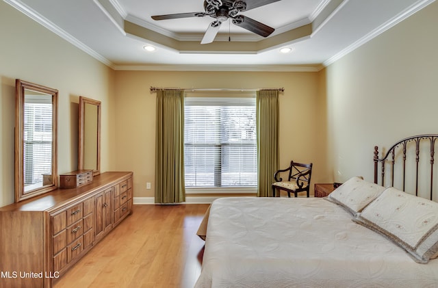 bedroom featuring baseboards, ornamental molding, a tray ceiling, light wood-type flooring, and recessed lighting