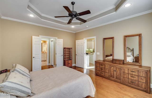 bedroom featuring a tray ceiling, crown molding, light wood-style flooring, and recessed lighting