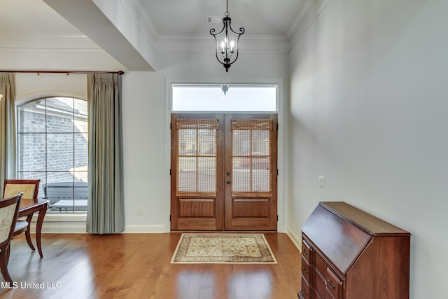 entrance foyer featuring a healthy amount of sunlight, crown molding, and wood finished floors