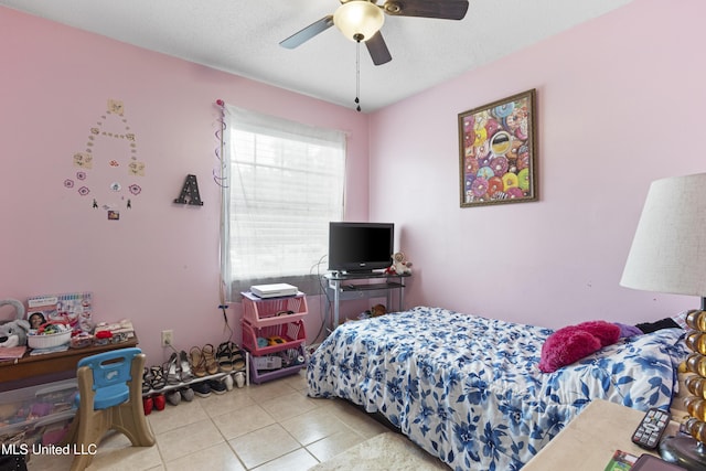 bedroom featuring light tile patterned flooring, ceiling fan, and a textured ceiling