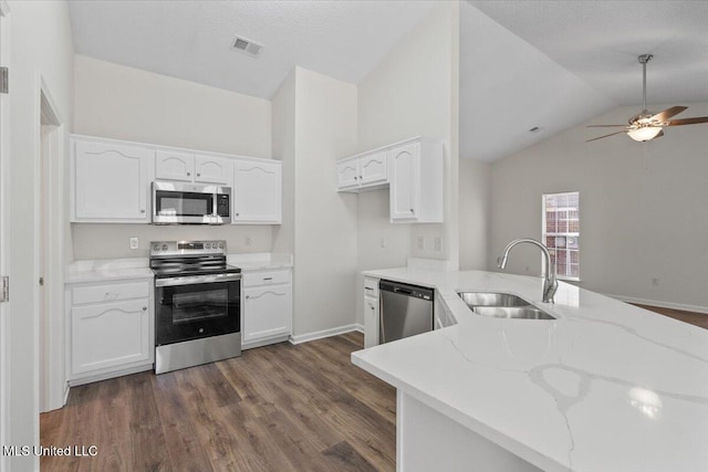 kitchen featuring visible vents, a sink, light stone counters, appliances with stainless steel finishes, and white cabinets