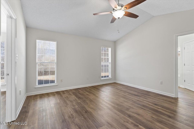 empty room with lofted ceiling, a textured ceiling, dark wood-style floors, baseboards, and ceiling fan