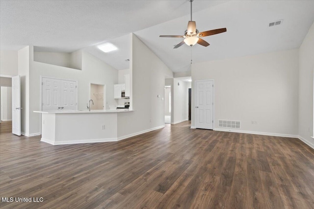 unfurnished living room featuring visible vents, baseboards, dark wood-type flooring, and ceiling fan