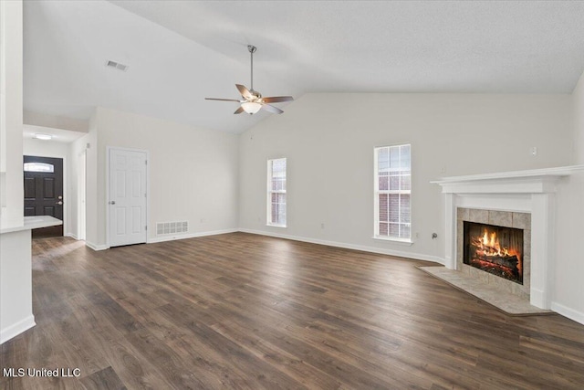 unfurnished living room featuring visible vents, dark wood finished floors, a fireplace, and a ceiling fan