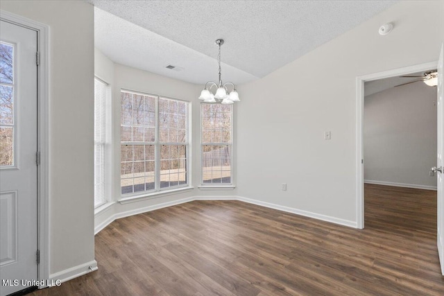 unfurnished dining area with dark wood-style floors, a wealth of natural light, and a textured ceiling