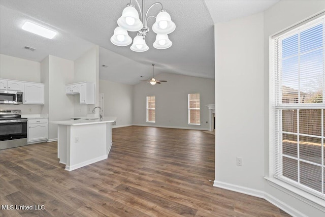 kitchen with visible vents, open floor plan, ceiling fan with notable chandelier, white cabinets, and stainless steel appliances