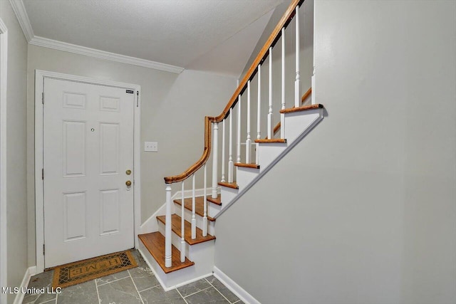 foyer with ornamental molding and a textured ceiling