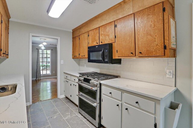 kitchen with tasteful backsplash, light stone countertops, range with two ovens, ceiling fan, and ornamental molding