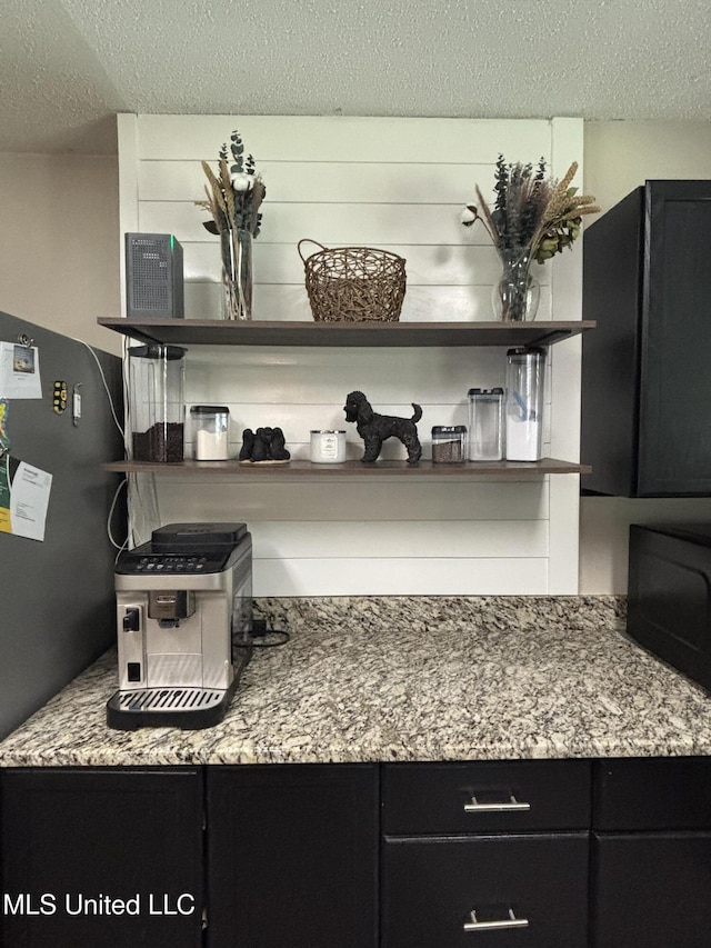 details with black microwave and a textured ceiling