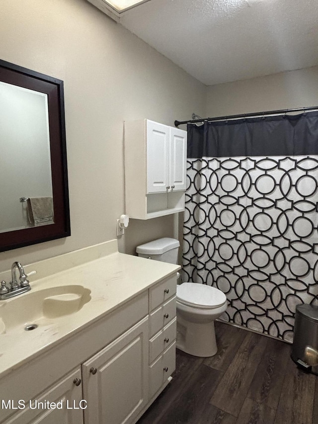 bathroom featuring toilet, a shower with curtain, vanity, and wood finished floors