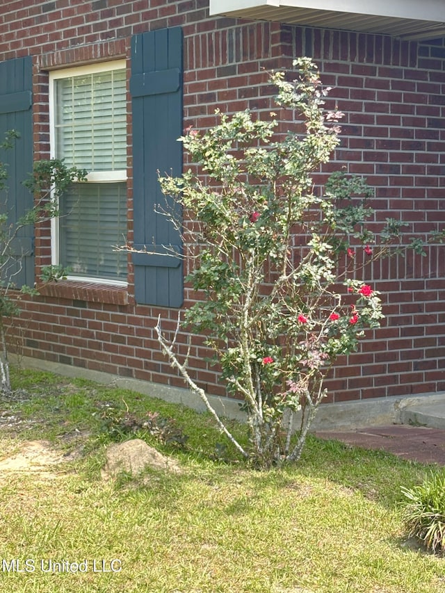 view of side of property featuring a lawn and brick siding