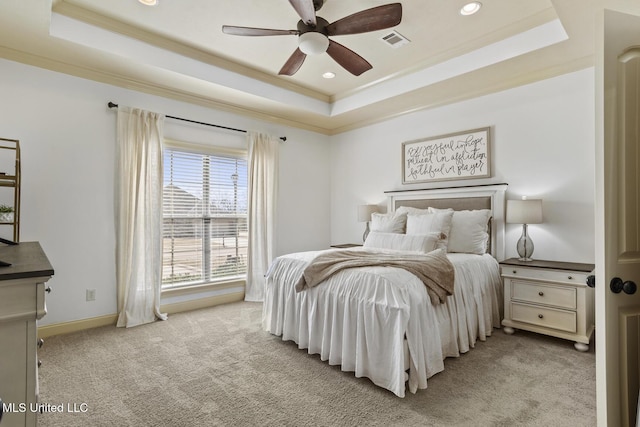 bedroom with a tray ceiling, ornamental molding, visible vents, and light carpet