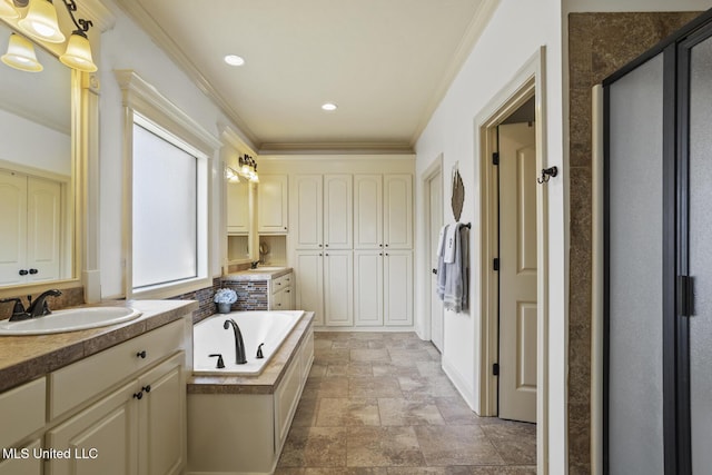 bathroom with crown molding, a garden tub, two vanities, a stall shower, and a sink