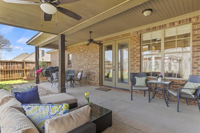 view of patio / terrace with ceiling fan, fence, french doors, an outdoor hangout area, and outdoor dining space