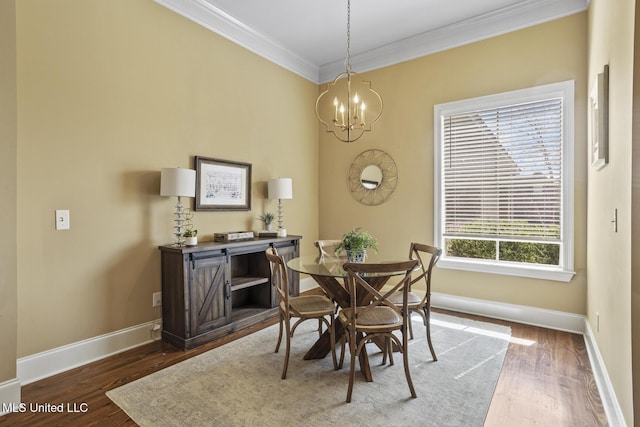 dining space with crown molding, a notable chandelier, wood finished floors, and baseboards