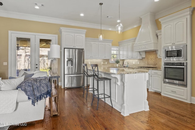 kitchen featuring visible vents, custom range hood, open floor plan, stainless steel appliances, and french doors